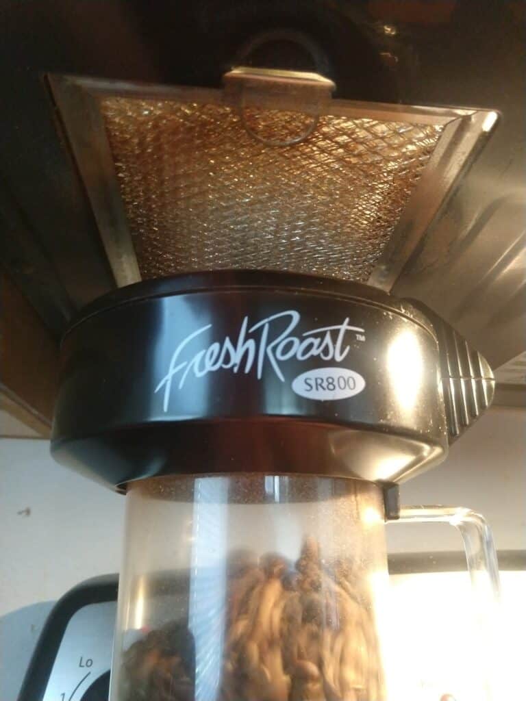 The Fresh Roast positioned under a vent fan to deal with smoke from coffee roasting